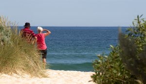 Two adults standing at the beach on Lakes Entrance