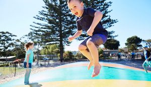 Young boy jumping on the bouncing pillow at Victor Harbor