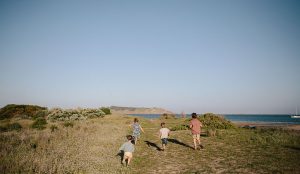 Four children running towards Encounter Bay