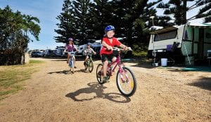 Three children riding bikes in Port Campbell