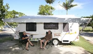 Couple sitting outside a caravan inside a Cairns Holiday Park