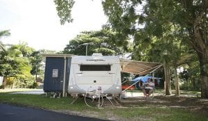 Man sitting next to his caravan inside a Cairns Holiday Park