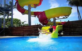 Kid on waterslide splashing into pool at NRMA Capricorn Yeppoon Holiday Park