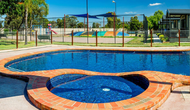 large swimming pool with a bouncing pillow in the background inside a yarrawonga caravan park