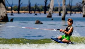 Young boy waterskiing on lake