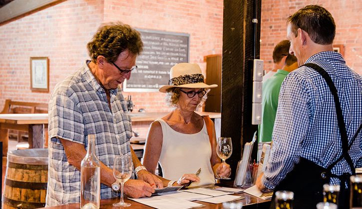 Older couple in a winery enjoying a taste test