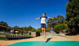 young boy jumping on a bouncing pillow inside a Halls Gap holiday and caravan park