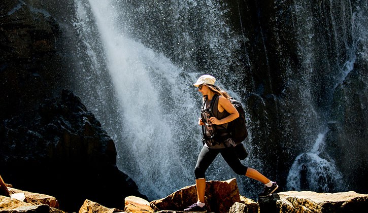 woman hiking past a waterfall in Grampians National Park