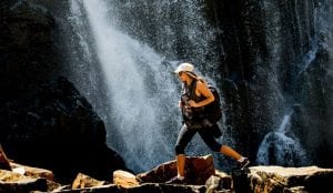 Woman hiking past a waterfall in the Grampians
