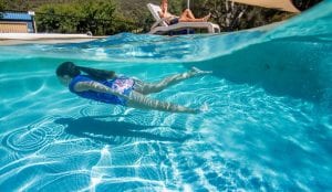 Girl swimming under water at a Halls Gap caravan park swimming pool