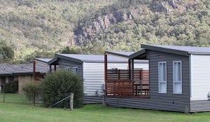 two cabins at a Halls Gap caravan park with a mountain in the background