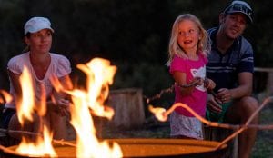 Young girl with parents cooking marshmallows over a fire at a Halls Gap caravan park