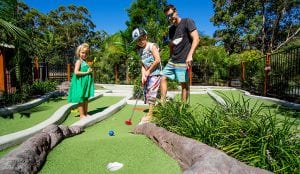 Young family playing mini golf in South West Rocks