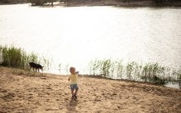 child near the murray river with a dog