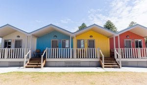 Row of colourful cabins inside a Shellharbour Holiday Park