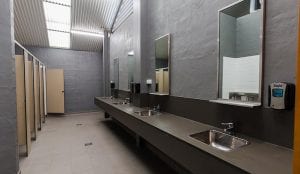 Amenities with sinks, toilets, showers and mirrors inside a Shellharbour holiday park