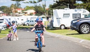young boy riding his bike through a caravan park in Shellharbour