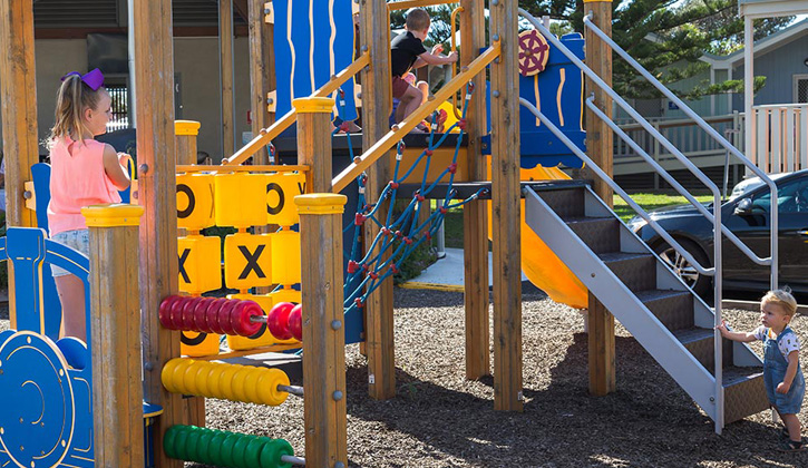 Children playing on a playground inside a Shellharbour caravan park