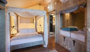 large bed and sleeping nook inside a glamping safari tent in merimbula