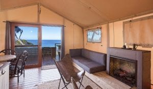 living area with fire place and views of the ocean from a merimbula glamping safari tent
