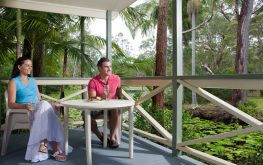 Couple sitting on a cabin balcony in Coffs Harbour