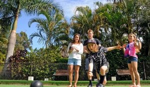 Family of four playing lawn bowls
