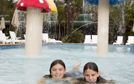 Two kids smiling in the Splash Away Bay park at NRMA Ocean Holiday Park