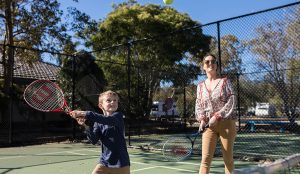Parent and child playing tennis