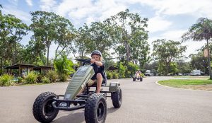 Child riding a petal go kart around the resort