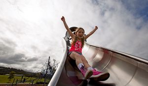 Child going down slide with an excited expression